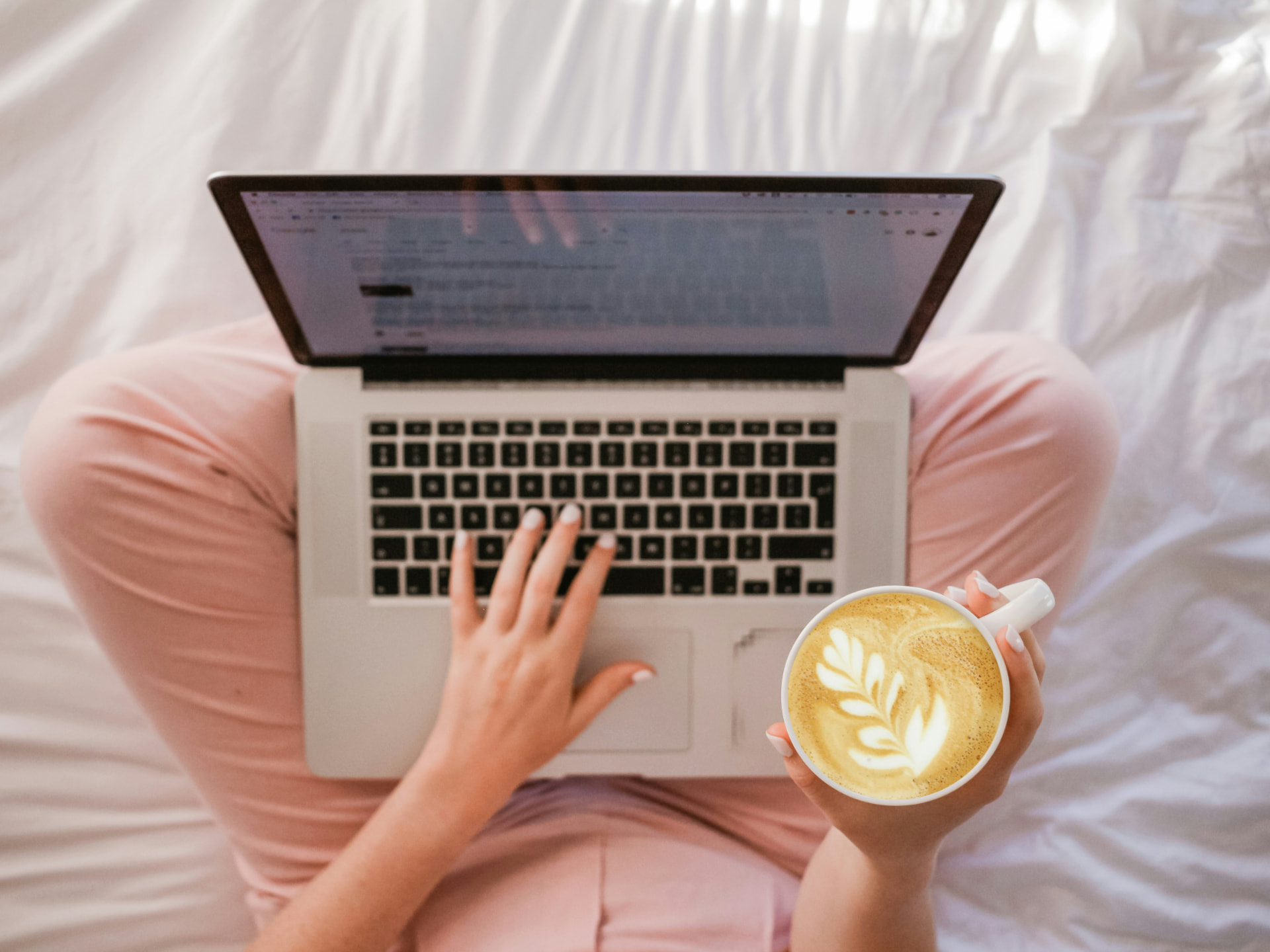 Pessoa escrevendo no notebook com um café ao lado, em um momento de leitura e reflexão